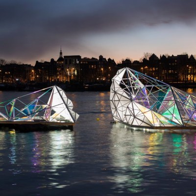 a small boat in a body of water with a city in the background